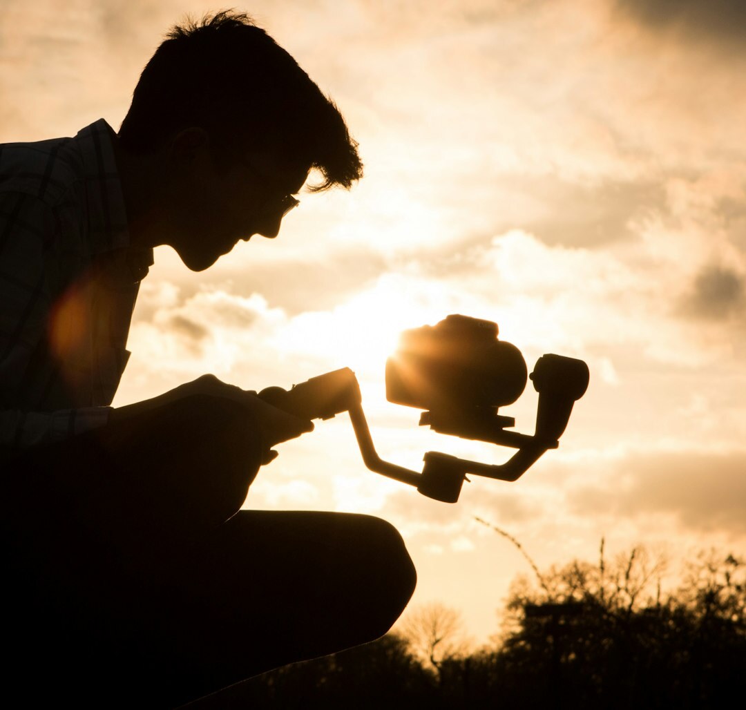 Video journalist reviewing footage on a camera screen in the field